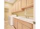Bright laundry room with light wood cabinets, a utility sink, and a modern washing machine at 2318 Shorewood Hills Ave, Henderson, NV 89052