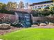 The community waterfall features lush landscaping and green grass at 2318 Shorewood Hills Ave, Henderson, NV 89052