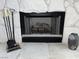 Close-up view of the living room fireplace with decorative tools and stone hearth at 2704 Otter Creek Ct # 101, Las Vegas, NV 89117