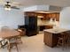 Cozy kitchen featuring wood cabinets, black appliances, breakfast bar, and adjacent dining area with wood table and chairs at 2704 Otter Creek Ct # 101, Las Vegas, NV 89117