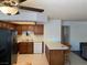 Bright kitchen featuring wood cabinets, white appliances, a breakfast bar with stools, and views into the adjacent living area at 2704 Otter Creek Ct # 101, Las Vegas, NV 89117