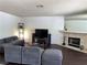 Comfortable living room with gray sectional sofa and stone fireplace at 2704 Otter Creek Ct # 101, Las Vegas, NV 89117