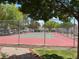 Outdoor community tennis court surrounded by a chain link fence, landscaping, and residential buildings at 2704 Otter Creek Ct # 101, Las Vegas, NV 89117