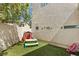 Backyard featuring artificial turf, patio area, a playhouse, outdoor dining set, and privacy fencing at 3367 Cheltenham St, Las Vegas, NV 89129