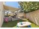 View of backyard featuring artificial turf, outdoor seating, play area, and privacy landscaping at 3367 Cheltenham St, Las Vegas, NV 89129