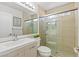 Bathroom features a glass enclosed shower, a mirror, a white vanity and beige ceramic tiling at 3367 Cheltenham St, Las Vegas, NV 89129