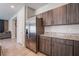 Modern kitchen with stainless steel refrigerator, granite countertops, and dark wood cabinets at 3815 Corellia Ave, North Las Vegas, NV 89084
