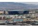 Wide aerial shot showcasing Allegiant Stadium, surrounded by the urban landscape of Las Vegas and mountains at 4381 W Flamingo Rd # 3120, Las Vegas, NV 89103