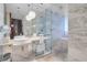 Sleek bathroom featuring double vessel sinks, marble tile, a glass shower and tub enclosure, and contemporary lighting at 4381 W Flamingo Rd # 3120, Las Vegas, NV 89103