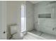 Bathroom featuring decorative tile, toilet, and frameless glass shower with grey stone trim and built in niche at 4454 Harmony Ct, Las Vegas, NV 89121