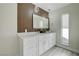 Modern bathroom featuring a marble countertop, wood-look accent wall, decorative lighting and a tall window at 4454 Harmony Ct, Las Vegas, NV 89121
