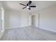 A spacious bedroom boasts gray toned wood flooring, neutral paint, and an overhead ceiling fan with lighting at 4454 Harmony Ct, Las Vegas, NV 89121