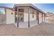 Exterior view of the home featuring a covered patio with stone landscaping and rear entrance at 4454 Harmony Ct, Las Vegas, NV 89121