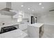 Modern kitchen showcasing white cabinets, quartz countertops, a stylish range hood, and stainless steel appliances at 4454 Harmony Ct, Las Vegas, NV 89121