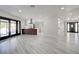 Open floor plan with modern kitchen views, a sleek breakfast bar, wood-look floors, and glass doors to the backyard at 4454 Harmony Ct, Las Vegas, NV 89121