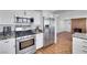 Updated kitchen showcases stainless steel appliances, granite countertops, brick floors and white cabinetry at 4680 Freshwater Dr, Las Vegas, NV 89103