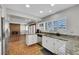Open kitchen featuring white cabinets, stainless steel appliances, granite countertops, and brick floors at 4680 Freshwater Dr, Las Vegas, NV 89103