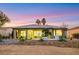 Scenic backyard featuring a covered patio, desert landscaping, and a manicured lawn under a colorful sky at 4718 Atlantico St, Las Vegas, NV 89135