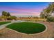 This backyard boasts synthetic grass, desert landscaping, and a fire pit at 4718 Atlantico St, Las Vegas, NV 89135