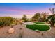 Beautiful backyard with desert landscaping, a green lawn, a fire pit and scenic golf course views at 4718 Atlantico St, Las Vegas, NV 89135