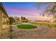 This backyard features synthetic grass, desert landscaping, and a fire pit at 4718 Atlantico St, Las Vegas, NV 89135