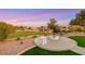 Landscaped backyard with a modern fire pit offering stunning views of the golf course at sunset at 4718 Atlantico St, Las Vegas, NV 89135