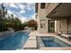 Expansive backyard with a sparkling pool, hot tub, grill, and patio seating, perfect for outdoor entertaining at 5 Moonfire Dr, Las Vegas, NV 89135