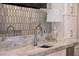 Close-up of a sink, faucet, and marble countertop in a stylish bar area with a lamp at 5 Moonfire Dr, Las Vegas, NV 89135