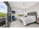 Inviting bedroom with tufted headboard, balcony, and stunning outdoor views, bathed in natural light at 5 Moonfire Dr, Las Vegas, NV 89135