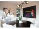Well-lit dining area with a round table, white chairs, and decorative artwork at 5 Moonfire Dr, Las Vegas, NV 89135