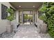 Inviting entryway featuring stone pavers, modern benches, decorative wall art, and a view of the open living space at 5 Moonfire Dr, Las Vegas, NV 89135