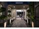 Inviting entryway with lush greenery, stone pathway, and modern benches leading to a bright, open living space at 5 Moonfire Dr, Las Vegas, NV 89135