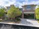 Stunning two-story home featuring a modern design, stone accents, glass garage door and beautifully landscaped front yard at 5 Moonfire Dr, Las Vegas, NV 89135