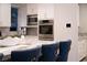 Close-up of the kitchen island with stylish seating, marble countertops, and modern appliances at 5 Moonfire Dr, Las Vegas, NV 89135