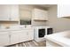 Efficient laundry room with modern washer and dryer, complemented by ample storage and countertops at 5 Moonfire Dr, Las Vegas, NV 89135