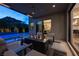 Inviting outdoor patio featuring a modern fire pit, comfortable seating, and ambient lighting near pool at 5 Moonfire Dr, Las Vegas, NV 89135