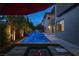 Beautiful backyard pool illuminated at night, surrounded by lush landscaping and comfortable lounge chairs at 5 Moonfire Dr, Las Vegas, NV 89135