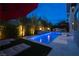 Backyard oasis featuring a sparkling pool, lush landscaping, and cozy lounge area for outdoor enjoyment at 5 Moonfire Dr, Las Vegas, NV 89135