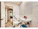 Accessible bathroom with marbled tile, grab bars, floating sink, and wood-look floors at 517 7Th St, Boulder City, NV 89005
