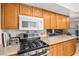Functional kitchen with gas range, microwave, and wooden cabinets for storage at 5181 Morris St, Las Vegas, NV 89122