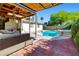 Beautiful pool area with covered patio, outdoor seating, and landscaped backyard at 5181 Morris St, Las Vegas, NV 89122