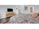 Spacious bedroom with a bed featuring a patterned comforter and a modern dresser with a TV at 5221 Tropical Peach Dr, Las Vegas, NV 89118