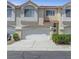 Neutral colored townhome with a two-car garage, tidy landscaping, and a front door at 5221 Tropical Peach Dr, Las Vegas, NV 89118