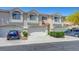 Townhome featuring a two-car garage, neutral stucco exterior, and a terracotta roof at 5221 Tropical Peach Dr, Las Vegas, NV 89118