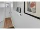Bright hallway with hardwood floors, a white door, and framed art on the white walls at 5221 Tropical Peach Dr, Las Vegas, NV 89118