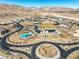 Stunning aerial view of the community showcasing modern homes, a pool, and desert landscape with mountain backdrops at 5436 Succulent Rose Dr, Las Vegas, NV 89135