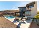 Backyard pool area with lounge chairs, covered patio, and mountain views at 5436 Succulent Rose Dr, Las Vegas, NV 89135