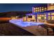 Stunning backyard showcasing a modern pool with a waterfall feature and a beautiful two-story home at dusk at 5436 Succulent Rose Dr, Las Vegas, NV 89135