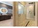 Modern bathroom features a glass shower with mosaic tile floor and dual vanity with a vessel sink and backlit mirror at 5436 Succulent Rose Dr, Las Vegas, NV 89135