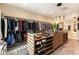 Large walk-in closet with extensive built-in shelving, hanging racks, and an island with glass top at 5436 Succulent Rose Dr, Las Vegas, NV 89135